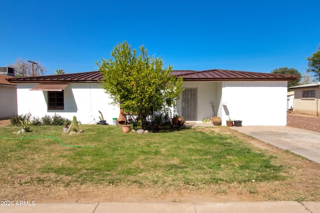 view of front facade featuring metal roof and a front yard