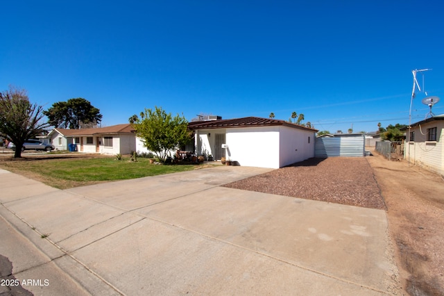 view of front of property featuring a front yard, fence, and driveway