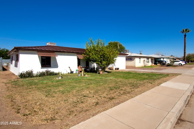 706 E Roosevelt Ave, Buckeye, AZ 85326 - view of front of house featuring a front yard, metal roof, and a chimney