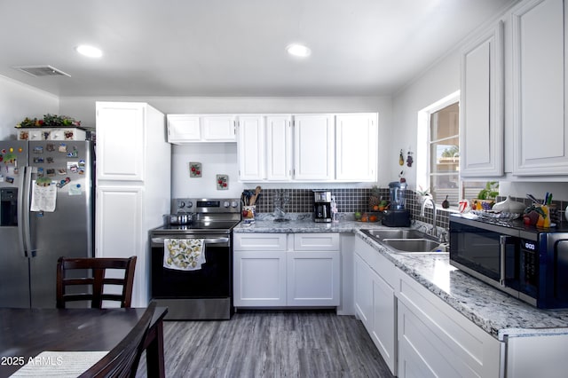 kitchen with white cabinetry, visible vents, appliances with stainless steel finishes, and a sink