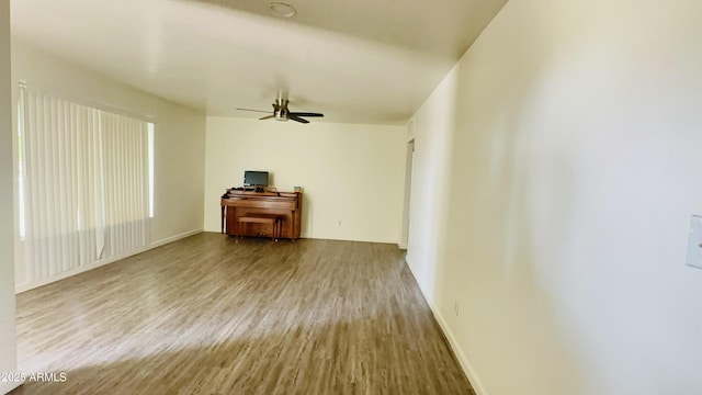706 E Roosevelt Ave, Buckeye, AZ 85326 - unfurnished living room with wood finished floors, ceiling fan, and baseboards