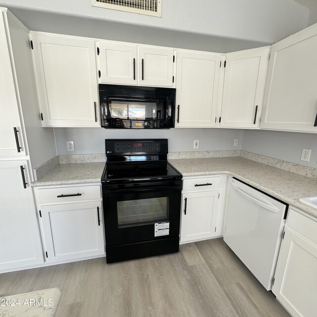 kitchen featuring black appliances, white cabinetry, and light hardwood / wood-style flooring