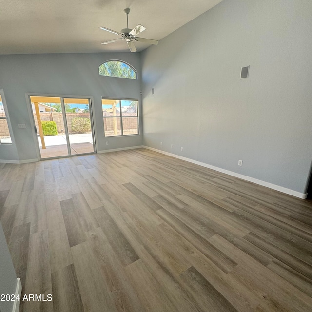 spare room featuring light wood-type flooring, a high ceiling, and ceiling fan