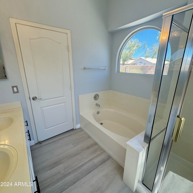 bathroom featuring plus walk in shower, hardwood / wood-style floors, and vanity