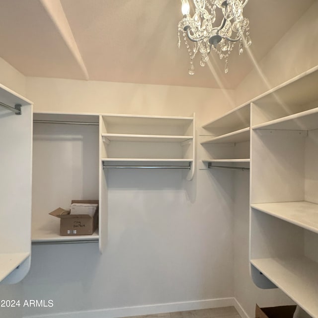 walk in closet with a notable chandelier