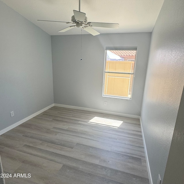 empty room featuring ceiling fan and light hardwood / wood-style flooring