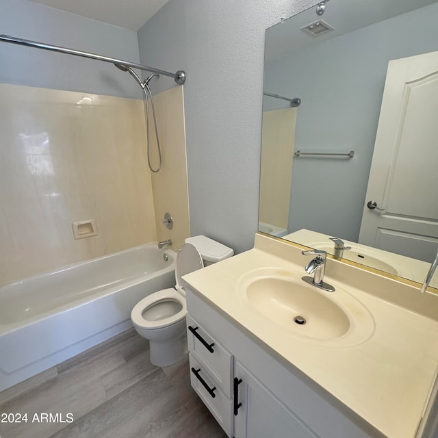 full bathroom featuring vanity, hardwood / wood-style floors, toilet, and shower / bathtub combination