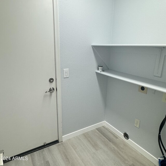 clothes washing area with light wood-type flooring