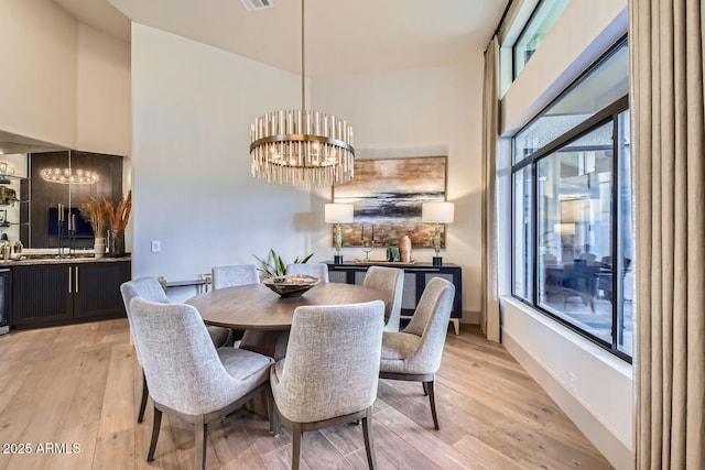 dining space featuring a notable chandelier and light wood-type flooring