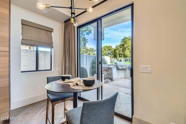 dining room with an inviting chandelier and light hardwood / wood-style flooring