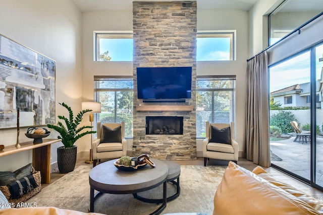 living room with a towering ceiling and a stone fireplace