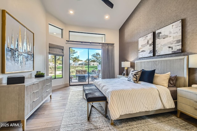 bedroom featuring light hardwood / wood-style flooring, access to outside, high vaulted ceiling, and ceiling fan