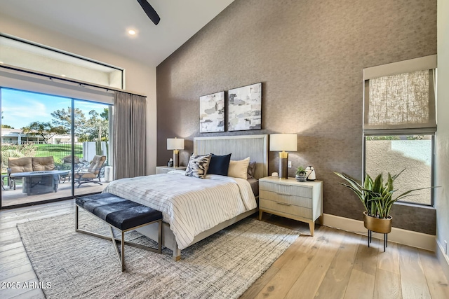 bedroom featuring ceiling fan, access to exterior, high vaulted ceiling, and light wood-type flooring