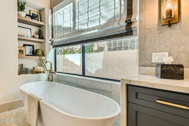 bathroom featuring vanity, built in features, and a washtub