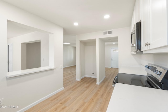 kitchen featuring white cabinets, appliances with stainless steel finishes, and light hardwood / wood-style flooring