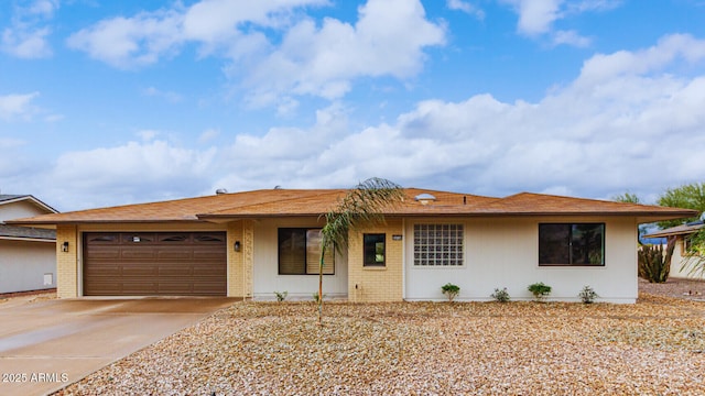 ranch-style home with an attached garage, brick siding, and driveway