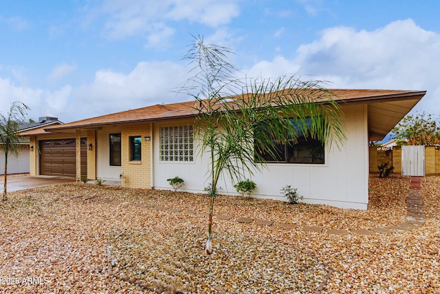 ranch-style house with concrete driveway, a garage, fence, and brick siding