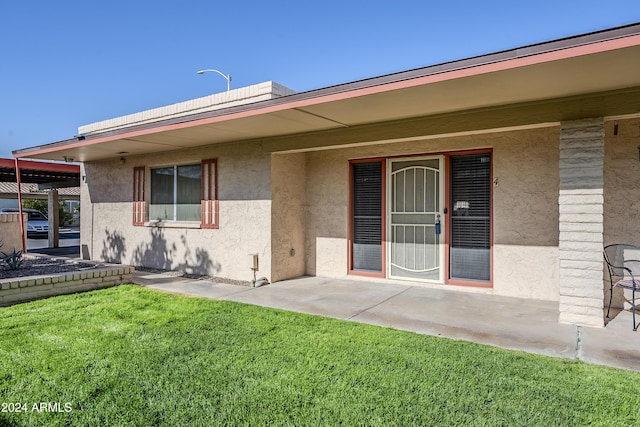 entrance to property with a yard and a patio