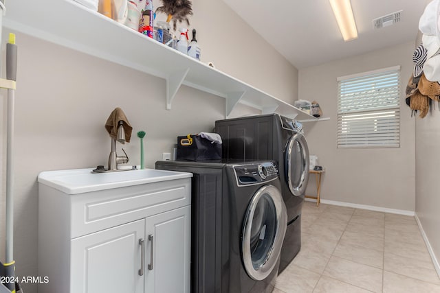 washroom with light tile patterned floors, baseboards, visible vents, washing machine and clothes dryer, and cabinet space