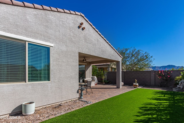 view of yard featuring a patio, a mountain view, and ceiling fan