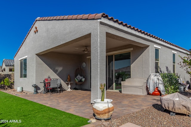 back of property with ceiling fan and a patio