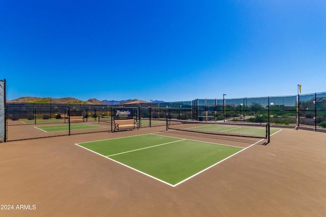 view of sport court with community basketball court, a mountain view, and fence