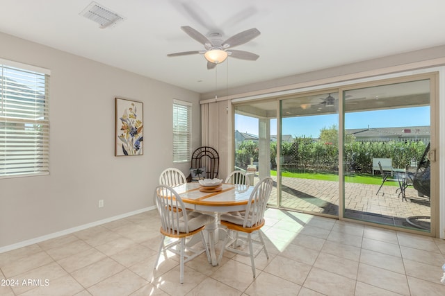 unfurnished dining area with light tile patterned floors, visible vents, ceiling fan, and baseboards