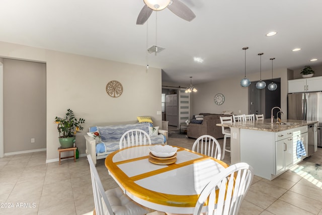 dining room with light tile patterned flooring, a barn door, sink, and ceiling fan