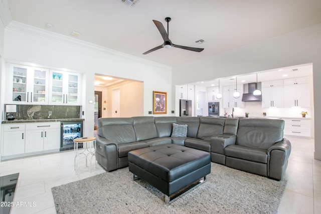 16772 W Cypress St, Goodyear, AZ 85395 - living area featuring beverage cooler, crown molding, light tile patterned floors, ceiling fan, and bar area