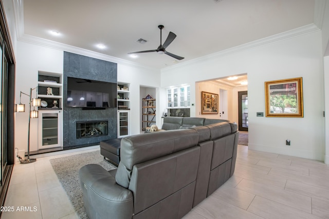 16772 W Cypress St, Goodyear, AZ 85395 - living area featuring a ceiling fan, crown molding, built in shelves, a fireplace, and baseboards