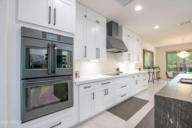 16772 W Cypress St, Goodyear, AZ 85395 - kitchen with wall chimney range hood, double wall oven, white cabinets, black electric stovetop, and recessed lighting