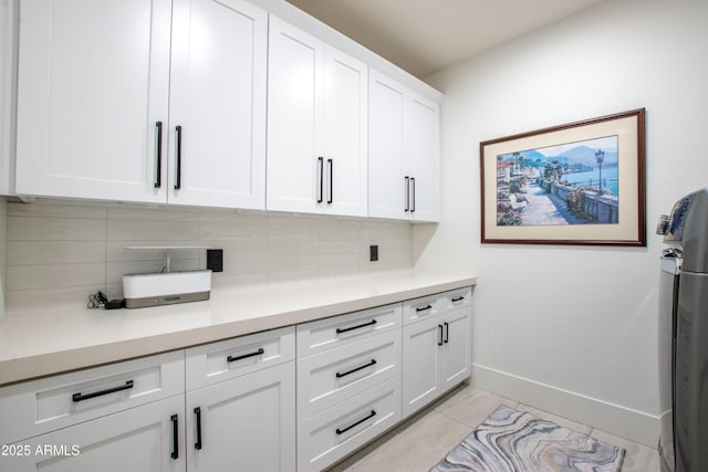16772 W Cypress St, Goodyear, AZ 85395 - kitchen with tasteful backsplash, baseboards, white cabinetry, light countertops, and light tile patterned floors
