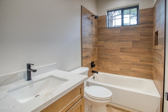 bathroom featuring washtub / shower combination, vanity, and toilet