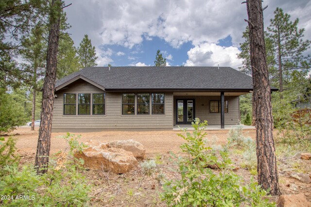 view of front of property featuring a shingled roof and a patio area