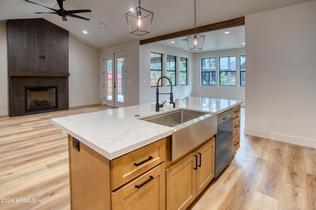 kitchen featuring lofted ceiling with beams, a fireplace, a sink, open floor plan, and stainless steel dishwasher