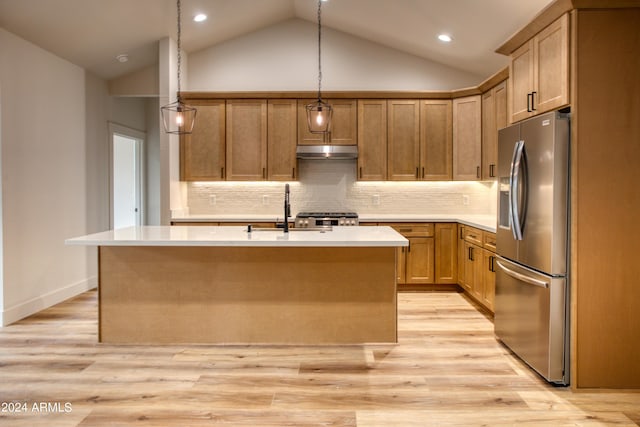 kitchen featuring stainless steel appliances, light countertops, light wood-type flooring, under cabinet range hood, and a sink