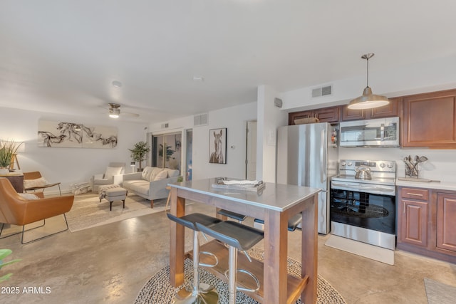 kitchen with visible vents, a ceiling fan, open floor plan, and stainless steel appliances