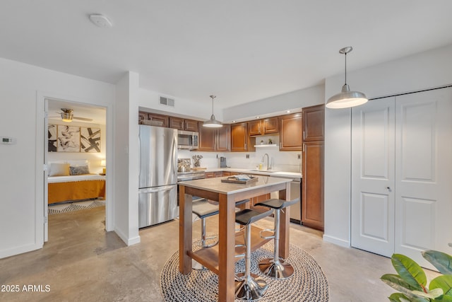kitchen with visible vents, light countertops, a sink, concrete floors, and appliances with stainless steel finishes