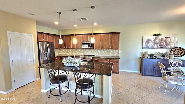 kitchen with stainless steel appliances, a kitchen island, backsplash, pendant lighting, and light tile patterned floors