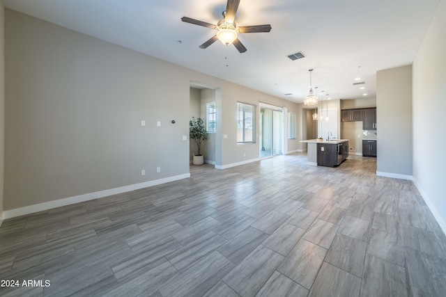 unfurnished living room with ceiling fan and sink