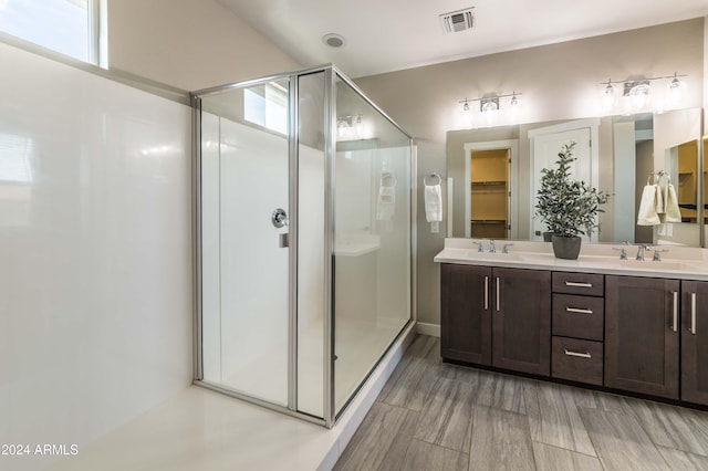 bathroom with hardwood / wood-style floors, vanity, and a shower with shower door