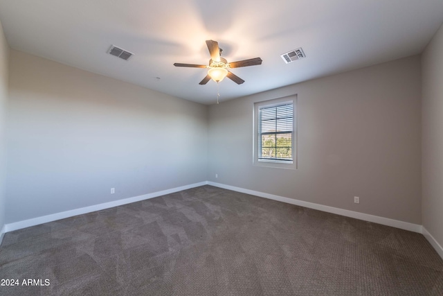 spare room featuring ceiling fan and dark colored carpet