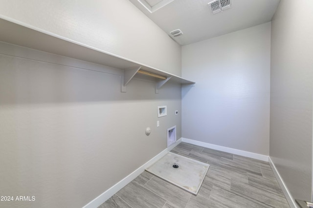 laundry area featuring hookup for an electric dryer, hookup for a gas dryer, light hardwood / wood-style floors, and washer hookup