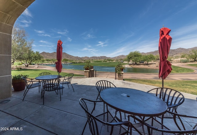 view of patio / terrace featuring a water and mountain view