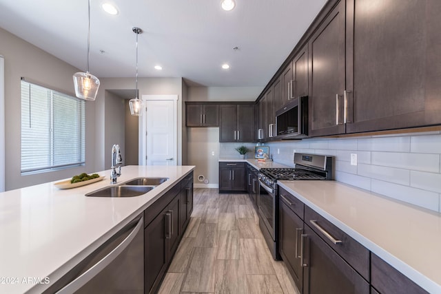 kitchen with tasteful backsplash, dark brown cabinetry, stainless steel appliances, sink, and pendant lighting