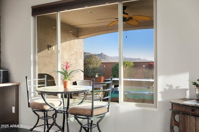 dining area with a mountain view and ceiling fan