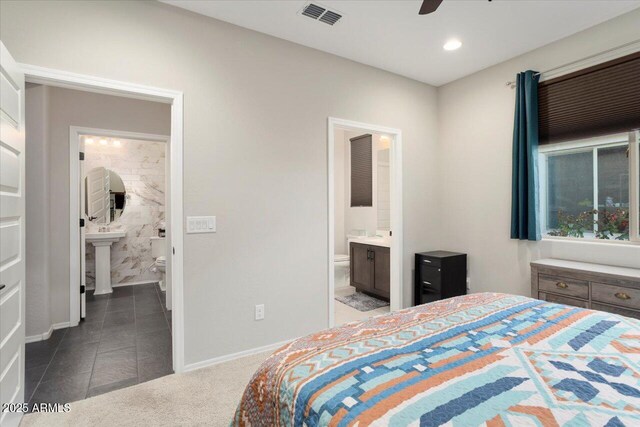 bedroom featuring ceiling fan, dark tile patterned floors, sink, and connected bathroom