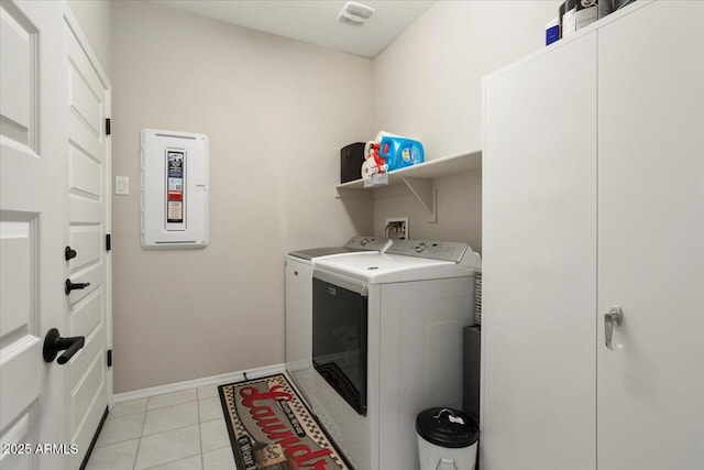 clothes washing area featuring light tile patterned flooring and washing machine and clothes dryer