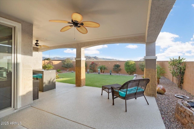 view of patio / terrace with a mountain view and ceiling fan