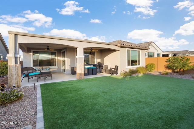 back of house featuring ceiling fan, a patio area, an outdoor living space, and a yard